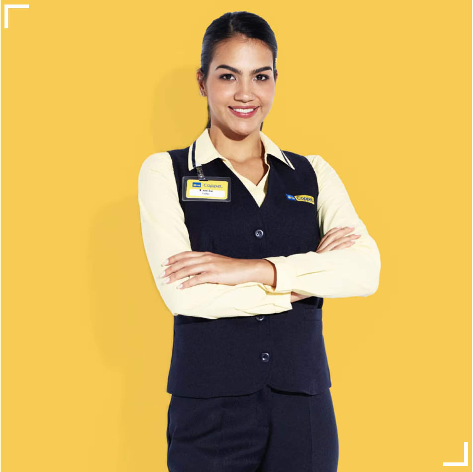 Trabajadora de Coppel con uniforme azul marino con amarillo y credencial de empleado.